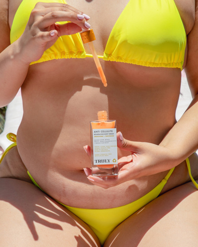 woman in yellow bikini with truly beauty anti cellulite serum